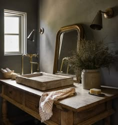 a wooden desk topped with a mirror next to a window