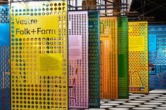 a row of brightly colored partitions on display in a building with black and white flooring