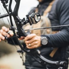 a man holding an archery bow and aiming it