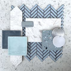 an assortment of different colored tiles on a white wall with grey grouting around them