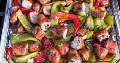 a pan filled with sausage and peppers on top of a stovetop oven grilling