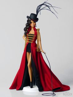 a barbie doll wearing a red dress and black hat with feathered tail, standing on a white base