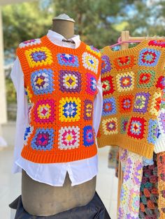 two crocheted vests are on display in front of a mannequin