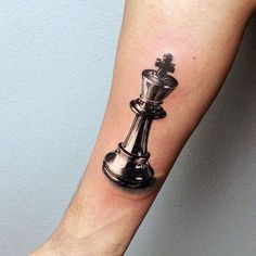 a black and white chess piece tattoo on the arm