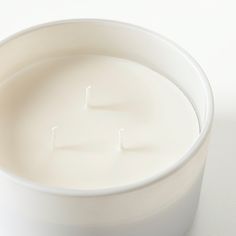 a close up of a candle in a white bowl