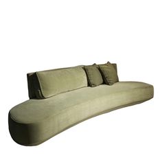 a curved couch with three pillows on it's back and two sides facing each other