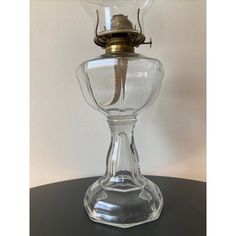 an old fashioned glass lamp with a small lizard on it's head, sitting on top of a table