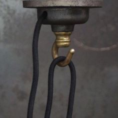 a close up of a metal object with a black cord hanging from it's end