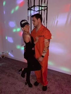 a man and woman in orange prison costumes posing for the camera with their arms around each other