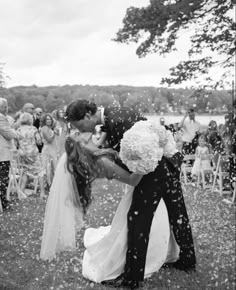 a bride and groom kissing in the middle of confetti thrown around them on their wedding day