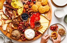 a person is holding a piece of bread in front of a platter of food