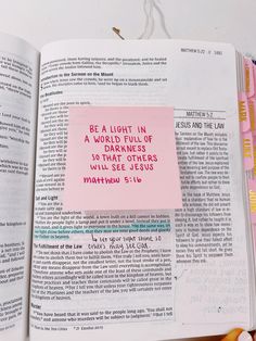 an open bible with sticky notes attached to the pages and colored markers on it's side