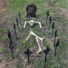 there is a skeleton sitting in the middle of many black poles that have been placed together