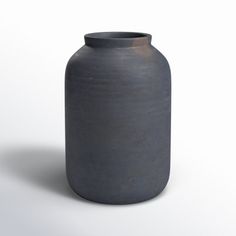 a gray vase sitting on top of a white table