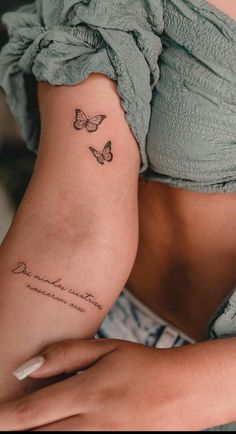 a woman's stomach with two butterflies on her left side, and the word love is