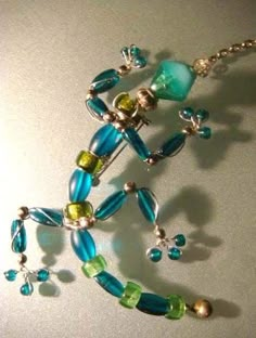 a blue and green beaded necklace on a table