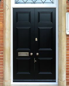 a black door with two sidelights on a brick building