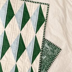 two green and white quilts sitting on top of each other