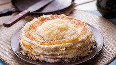 a stack of pancakes sitting on top of a plate next to a knife and spatula