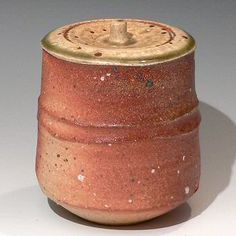 a brown ceramic container with a lid on it