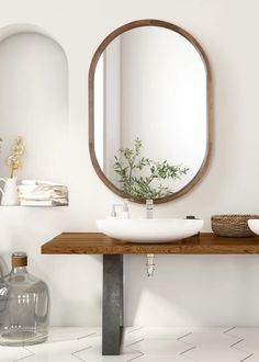 a bathroom sink sitting under a round mirror