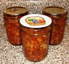 three jars filled with food sitting on top of a counter