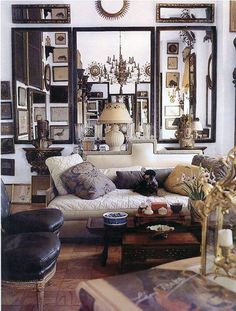 a living room filled with furniture and lots of mirrors