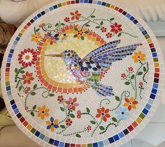 a colorful mosaic plate with a bird on it