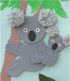 a paper cut out of a koala bear on a tree with pom - poms