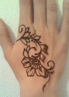 a woman's hand with a flower tattoo on it