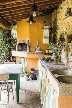 an outdoor kitchen with sink, stove and table in front of the counter top area