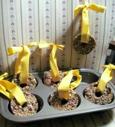 some cupcakes with yellow bows are in a muffin tin on a table