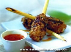 two skewered meats on a plate with dipping sauce