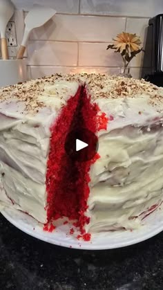 a cake with white frosting and red sprinkles