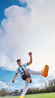 a man kicking a soccer ball on top of a field