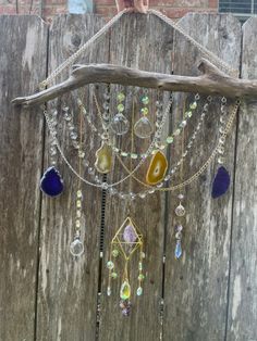 a close up of a piece of wood with beads and chains hanging from it's side