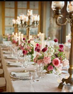 a long table is set with flowers and candles for an elegant dinner or reception party