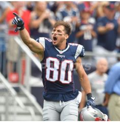 a football player holding his hands up in the air