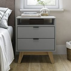 a nightstand with two drawers and a plant in the window sill next to it