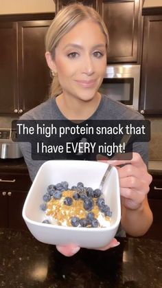 a woman holding a bowl of cereal with the caption'the high protein snack that i have every night '