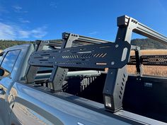 the back end of a pickup truck with two large metal racks on it's flatbed