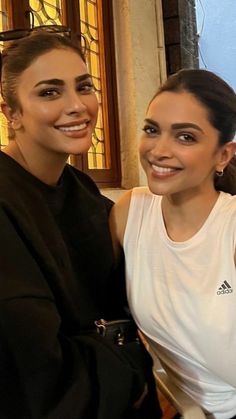 two women sitting next to each other smiling