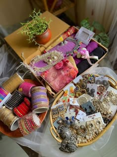 two baskets filled with assorted jewelry on top of a table next to a potted plant