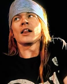 a young man with long hair wearing a bandana and looking up at the sky