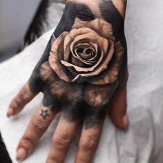 a person's hand with a rose tattooed on it