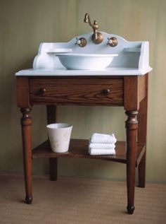 a white sink sitting on top of a wooden table