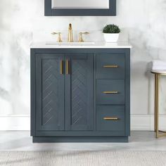 a bathroom vanity with a mirror above it and two gold faucets on the sink