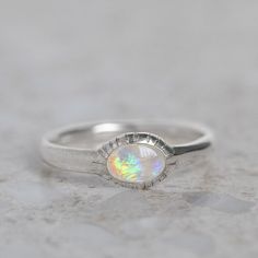 Our ancient inspired Parthian stacking ring is set with an oval crystal opal from Coober Pedy. Opal measures 6 x 4mm. Approx band width 2.6mm - 1.7mm at back of band. Approx weight: 2.3g in silver, 2.5g in 9ct gold. Pictured in first image with a matte finish. For a high shine finish please leave a note at checkout. Please note, we will match the opal as close to the image as possible. Each opal is unique and may vary in appearance and colour from what is depicted on the site. Spiritual Oval Opal Promise Ring, Spiritual Oval Opal Ring, Spiritual Oval Opal Birthstone Ring, Oval Opal Stackable Rings As Gift, Oval Opal Stackable Rings, Stackable Oval Opal Rings, Adjustable Stackable Oval Opal Ring, Opal Stacking Ring, Coober Pedy