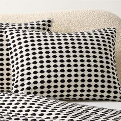 two black and white pillows sitting on top of a bed next to a pillow case