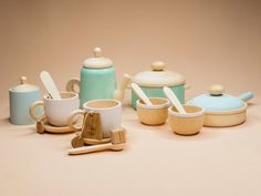 a table topped with cups and saucers next to wooden spoons